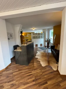 Empfangsbereich von AINHOA BEAUTY-WERK mit Theke, Sofa und Regalen